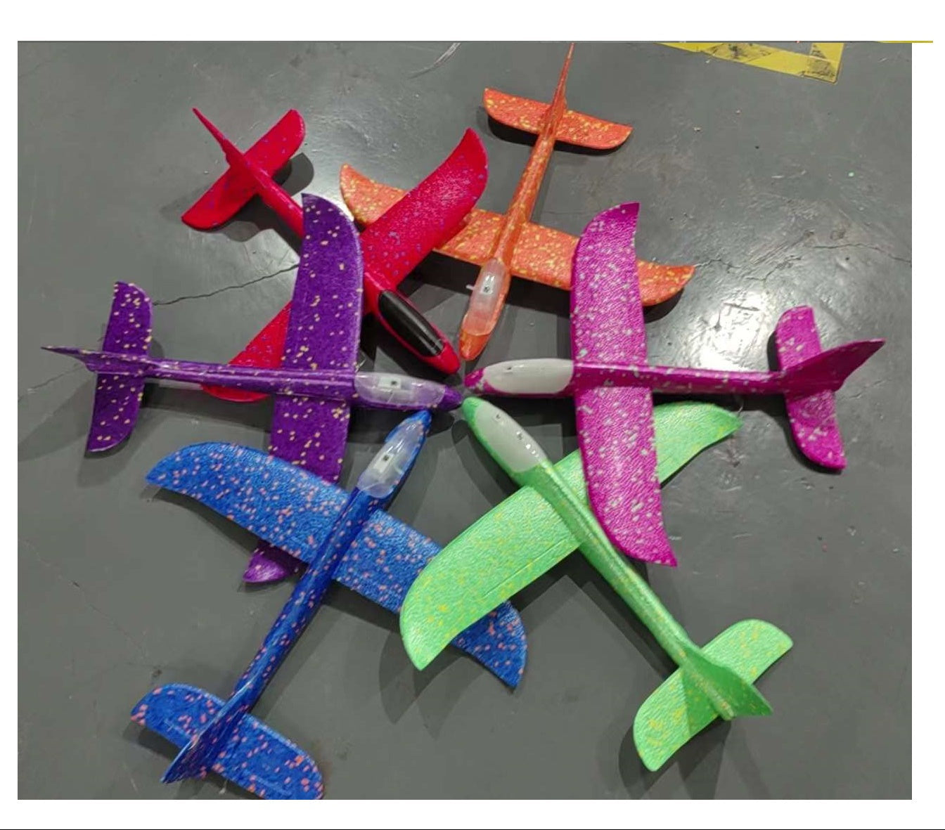 Colorful toy airplanes with light on a gray surface