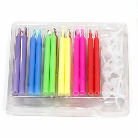 Set of colorful birthday candles with rainbow flames in packaging on a white background